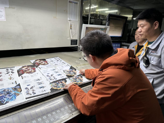 图说：工作人员对画册进行现场校色